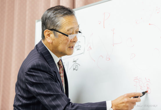 経営や人生観についてホワイトボードを使いながら解説する講師の講義風景