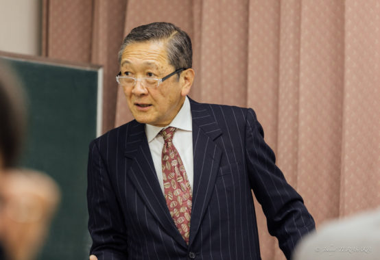 講師が真剣な表情で受講者に語りかけ、経営の課題について説明している講話の様子